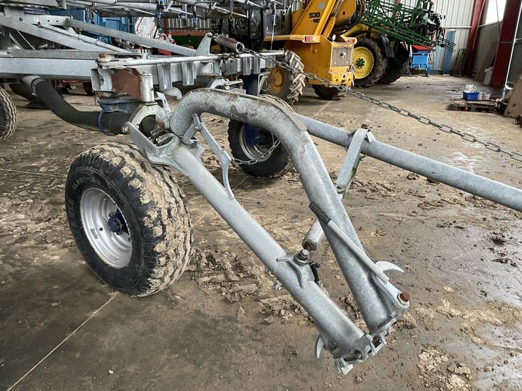 La rampe est reliée à l’enrouleur et alimentée en eau par une conduite qui se replie au transport. 