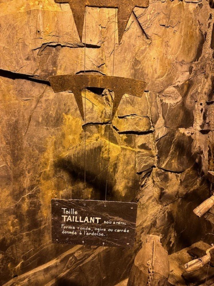 Les outils des ardoisiers, les mêmes depuis trois siècles, sont présentés dans le musée du site des Pans de Travassac. Là, un taillant.