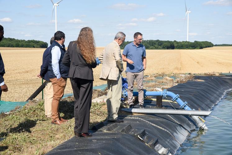 Mardi 8 juillet, à Luplanté. Thibaud Guillou (à d.) montre au préfet Hervé Jonathan (au c.) le principe de fonctionnement du bassin tampon de son système d'irrigation qui lui permet de se diversifier.
