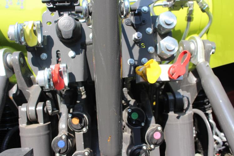 A l’arrière d’un tracteur Claas, en jaune et rouge : à gauche, les sorties de freinage pneumatiques, à droite les hydrauliques.