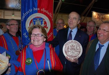 Les confréries des bries de Melun et de Meaux sont toujours présentes sur la foire. Ici aux côtés du nouveau président du comité de foire, André Mouilleron, Alain Juppé s’est vu remettre des morceaux de brie — ici le M’lun.

