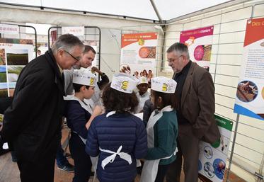 Le président de la chambre d’Agriculture échange avec des élèves d’une école primaire qui tentent de reconnaitre le blé à différents stades sur des cartes-photos.