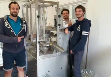 Les trois entrepreneurs dans leur nouveau laboratoire aux Alluets-le-Roi posent devant l’une des nouvelles machines : une empaqueteuse de 46000 euros.