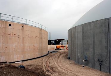 À gauche, le digesteur en cours de construction, au toit plat. Le digestat sous sa forme liquide est quant à lui stocké dans la cuve de droite, dotée d'un gazomètre.