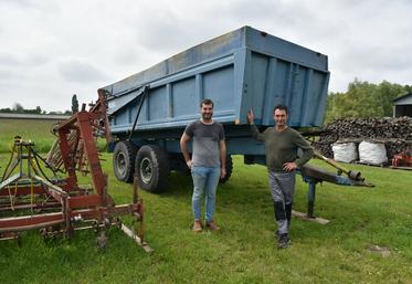 Jérôme Delouche et Bruno Chevallier, à Coudroy, siège social de la Cuma* du Canal, devant le plus ancien engin de la structure : une benne de 38 ans.