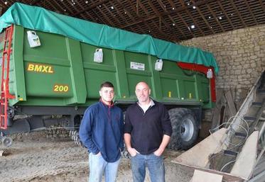 Benoit Durand (à d.) et son fils Germain, sous le bâtiment dont le toit a été criblé par la grêle.