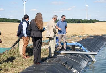 Mardi 8 juillet, à Luplanté. Thibaud Guillou (à d.) montre au préfet Hervé Jonathan (au c.) le principe de fonctionnement du bassin tampon de son système d'irrigation qui lui permet de se diversifier.