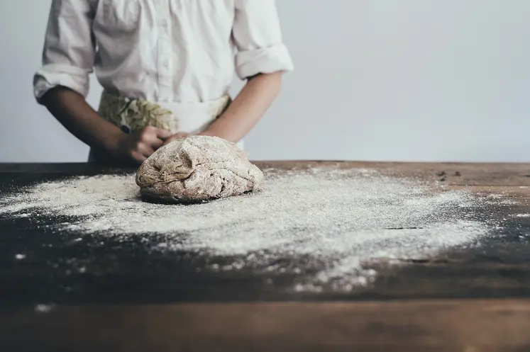 Un boulanger fait son pain avec de la farine.