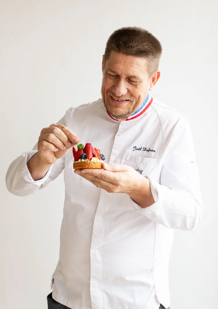 Le boulanger MOF, Joël Defives, avec une pâtisserie à base de blé dur Panzani solutions dans la main.