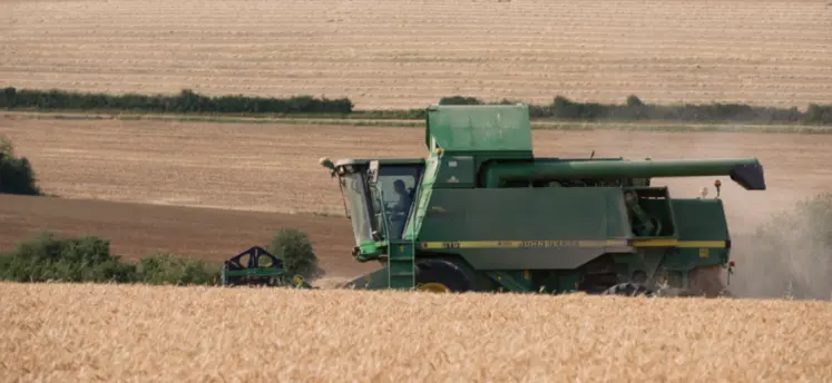 photo d'une moissonneuse dans un champ de céréales.