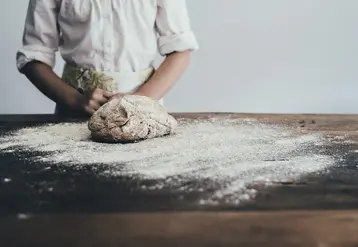 Un boulanger fait son pain avec de la farine.