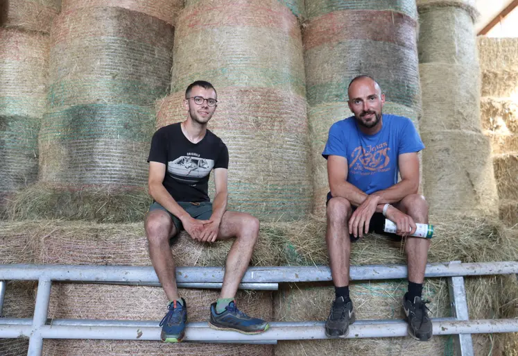 Hugo Barraillé et Florian Gibaud, deux éleveurs assis devant des bottes de paille