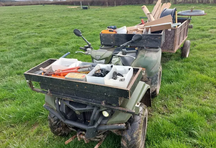 quad dans une prairie avec du matériel pour entretenir et déplacer les clôtures et les fils. 