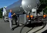 Collecte de lait  Massif du Sancy . Salarié de la laiterie chez l'éleveur près du camion