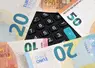 Calculator keyboard surrounded by euro banknotes close-up | Clavier de calculatrice entouré de billets de banque en euros en gros plan