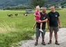 Deux éleveurs avec une petite fille devant un près avec des montbéliardes en Haute-Savoie