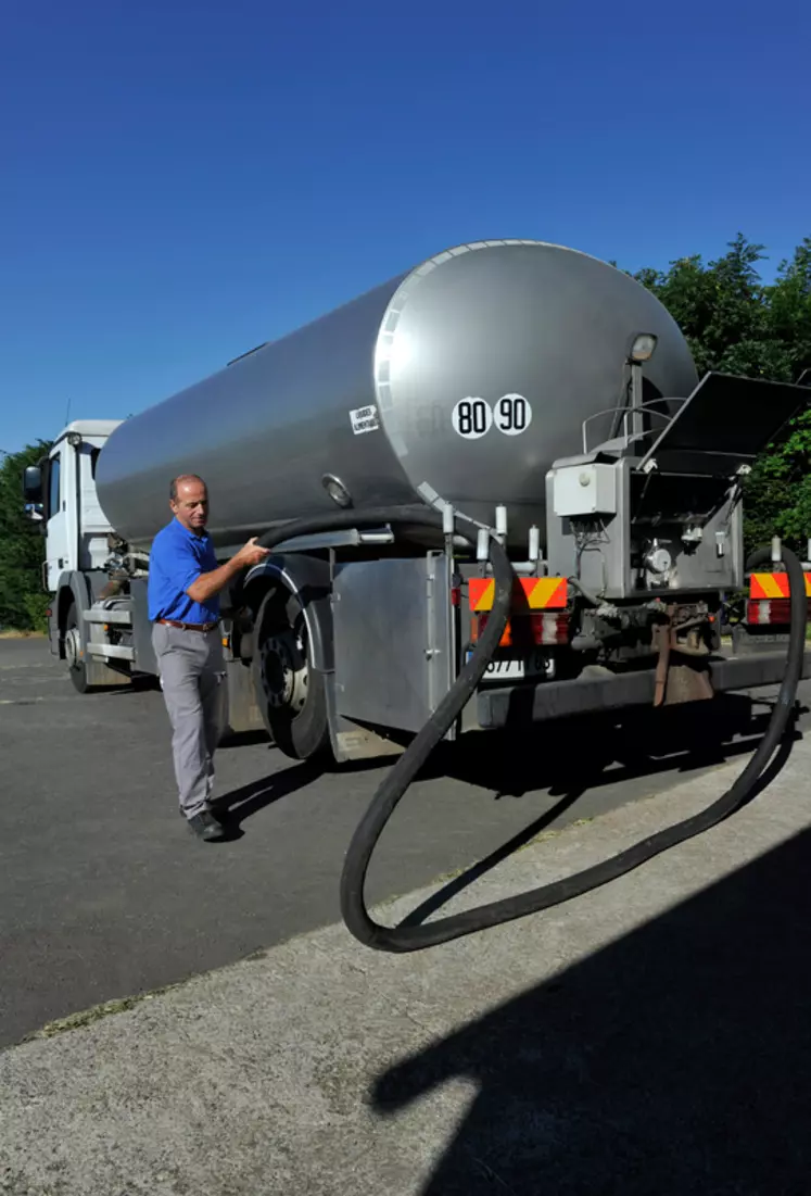 Collecte de lait par la Société laitière des Monts d'Auvergne chez les éleveurs du Massif du Sancy pour la fabrication de Saint-Nectaire AOP. Salarié de la laiterie chez l'éleveur près du camion, dans la cour de ferme. Industrie agroalimentaire.