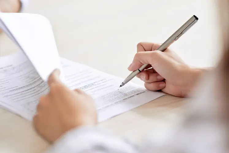 <em class="placeholder">Crop shot of person with pen signing contract at desk in daylight</em>