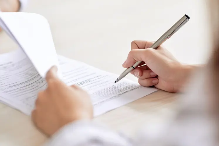 <em class="placeholder">Crop shot of person with pen signing contract at desk in daylight</em>