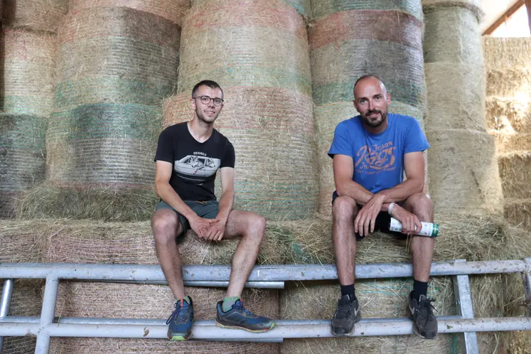 Hugo Barraillé et Florian Gibaud, deux éleveurs assis devant des bottes de paille