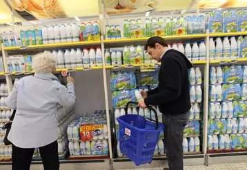 Vente de lait de vache en grande distribution. Achat de lait UHT par des clients de supermarché. Consommateur au profil de célibataire choisissant un petit conditionnement. ...