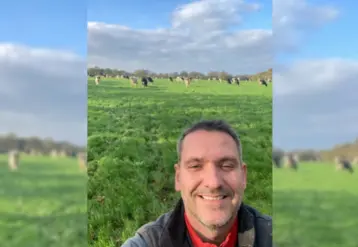 Selfie de Yohann Allain dans son champ avec ses vaches laitières.