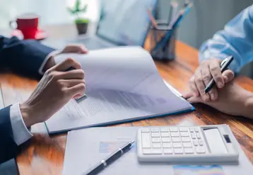 <em class="placeholder">Businesswoman reviewed mortgage document and contract with their client, ensuring loan and credit details were clear, while discussing estate insurance and other finance ...</em>