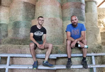 Hugo Barraillé et Florian Gibaud, deux éleveurs assis devant des bottes de paille