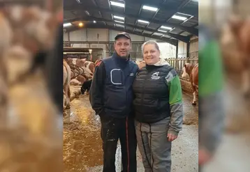 Nicolas et Christelle Braux dans la stabulation devant des vaches simmental