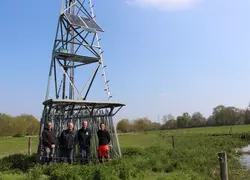 Groupe d'éleveurs devant une éolienne de pompage