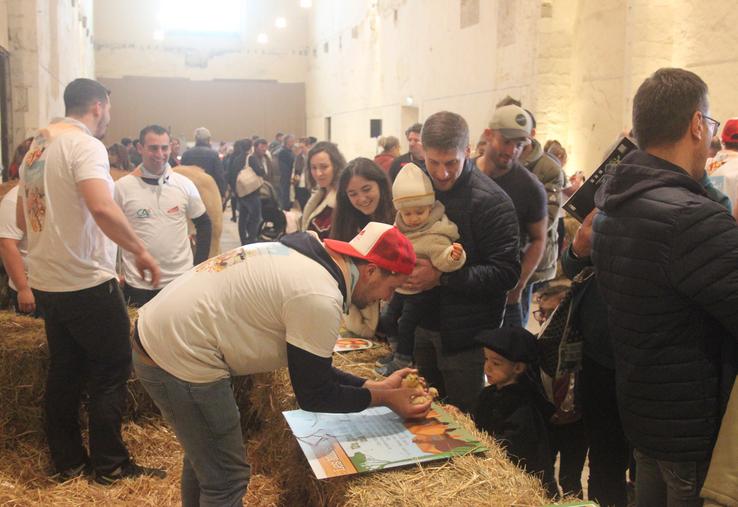 Un jeune agriculteur présente des poussins à une enfant dans une ambiance champêtre