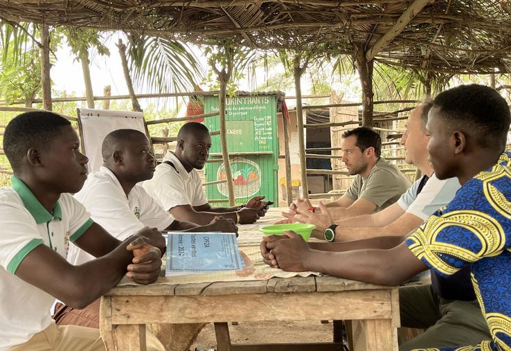 Des représentants de l'AFDI 40 avec des membres d'une école de l'AJAM à Lakossa, autour d'une table.