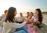 Un groupe de jeunes partage un pique-nique sur la plage