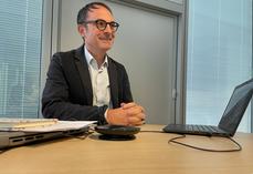 Thomas Chambolle sourit derrière son bureau