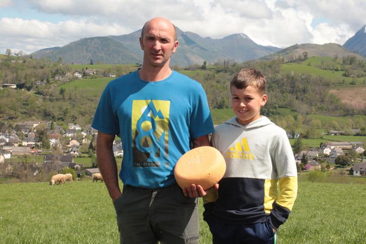 Joseph Libarle et son fils, dans une prairie, présentent un tomme de fromage