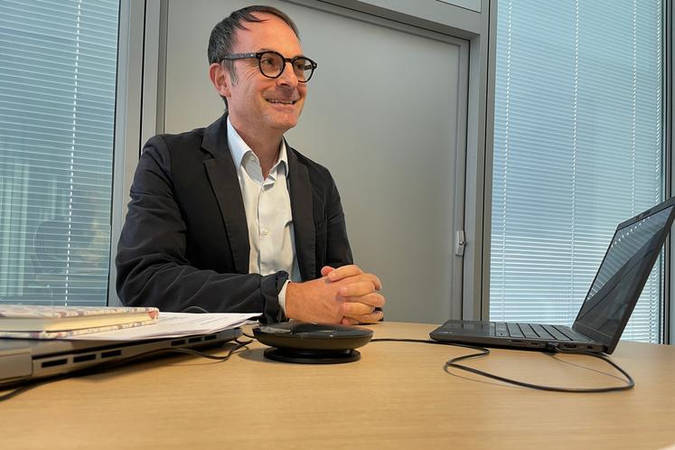 Thomas Chambolle sourit derrière son bureau