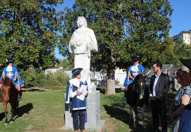 Des bénévoles de l’association en habit de mousquetaire avec des élus d'Oloron devant la statue du comte de Tréville 