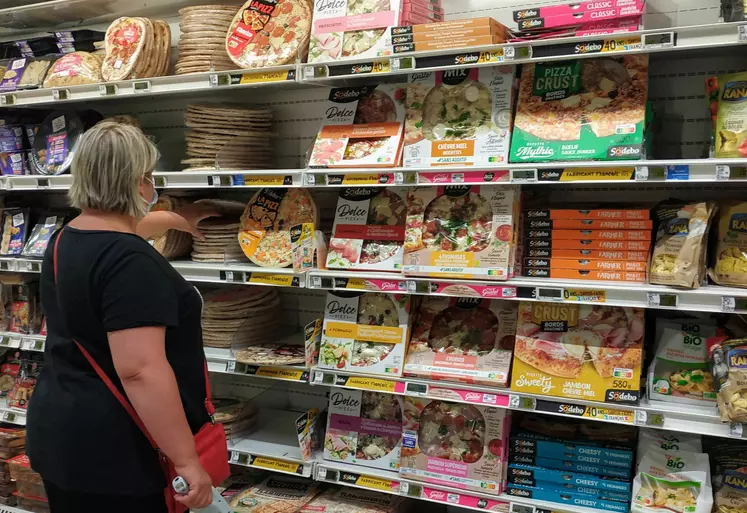 femme au rayon pizza d'un supermarché