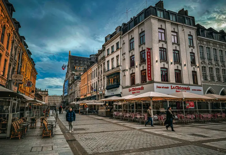 un groupe de personnes marchant dans une rue à côté de grands immeubles