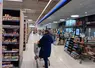 femme qui fait des courses avec un chariot au supermarché