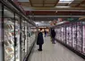 clients devant les vitrines réfrigérées d'un supermarché