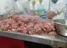 ouvriers de l'agroalimentaire devant de la viande