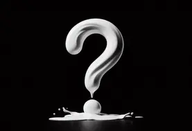 un point d'interrogation fait de lait renversé sur fond noir