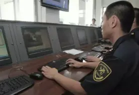 douanier chinois devant son ordinateur