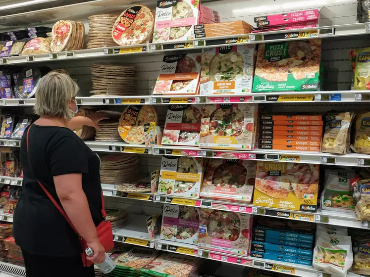 femme au rayon pizza d'un supermarché