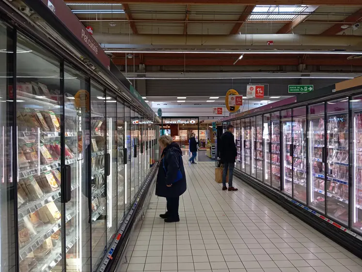 clients devant les vitrines réfrigérées d'un supermarché