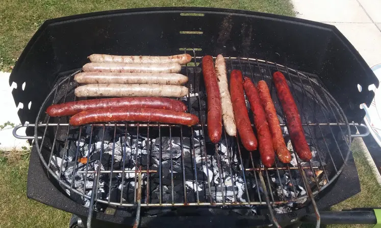 saucisses de chipolatas en cuisson sur barbecue