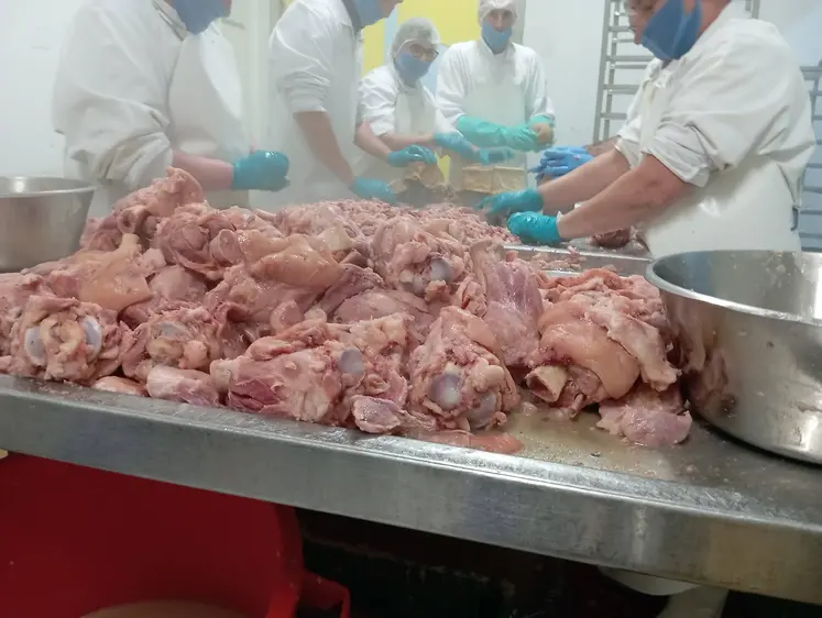 ouvriers de l'agroalimentaire devant de la viande