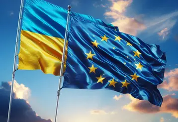 un drapeau de l'Ukraine et un drapeau de l'union européenne flottent au vent cote sur fond de ciel bleu 