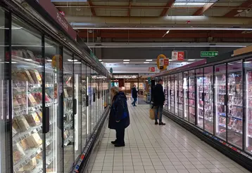 clients devant les vitrines réfrigérées d'un supermarché